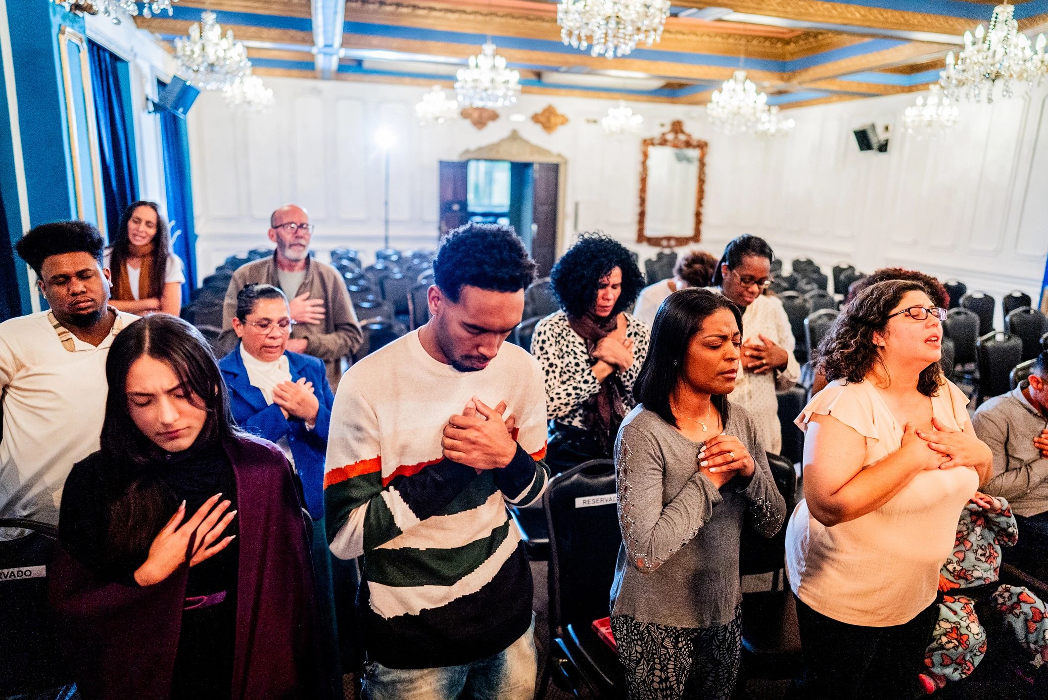 Diverse group praying together in church